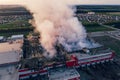 Aerial view of burnt industrial warehouse or logistics center building after big fire with huge smoke from burned roof Royalty Free Stock Photo