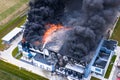 Aerial view of burnt industrial warehouse or logistics center building after big fire with huge smoke from burned roof