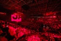 Business crowd enjoying concert in illuminated red stadium Royalty Free Stock Photo