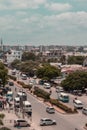 Aerial view of a bustling cityscape with various vehicles and people passing through the streets