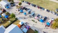Aerial view busy parking lot near row of colorful tents with people shopping at farmer market near Dallas, Texas, USA