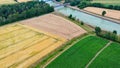 Aerial view of a canal that runs through fields, meadows and arable land in the flat landscape of northern Germany