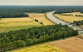 Aerial view of a canal that runs through fields, meadows and arable land in the flat landscape of northern Germany
