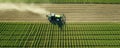 Aerial View Captures Tractor Fertilizing Green Field