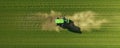 Aerial View Captures Tractor Fertilizing Green Field