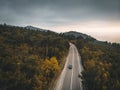 Aerial view of car on autumn mountain asphalt road, travel in Europe on transport concept, drone shot with copy space Royalty Free Stock Photo