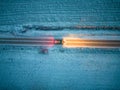 Aerial view of a car driving through a forest at dusk in winter time. Shot taken by a drone Royalty Free Stock Photo