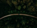 Aerial view of a car driving on a highway road between forests perfect for wallpapers