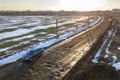 Aerial view of car moving along muddy rural road in bad condition on sunny spring or winter day Royalty Free Stock Photo