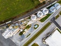 Aerial view of a cargo train by a farm with tall grain elevators and tanks in Delaware