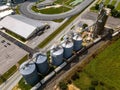 Aerial view of a cargo train by a farm with tall grain elevators and tanks in Delaware