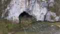 Aerial view of a cave entrance and mountain river. Unguru Mare cave, Suncuius, Romania