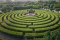 Aerial view of a circular garden maze and green pavilion