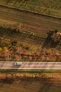 Aerial view of cistern truck on road through autumnal countryside landscape