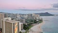 Aerial view of cityscape Honolulu surrounded by buildings and water during sunset