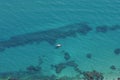 Aerial view of clear blue water and yellow boat