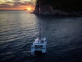 Aerial view of a cliff overlooking the sea and a catamaran moored at sunset, boat. Buljarica Beach. Montenegro