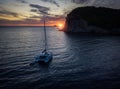 Aerial view of a cliff overlooking the sea and a catamaran moored at sunset, boat. Buljarica Beach. Montenegro