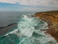 Aerial view of a cliff in the portuguese coastline with ocean waves and brown rocks Royalty Free Stock Photo