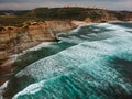Aerial view of a cliff in the portuguese coastline with ocean waves and brown rocks Royalty Free Stock Photo