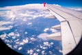 Aerial view of cloud blue sky and plane wing view through the airplane window. Royalty Free Stock Photo