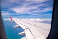 Aerial view of cloud blue sky and plane wing view through the airplane window. Royalty Free Stock Photo