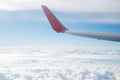 Aerial view on clouds and airplane wing in blue sky.