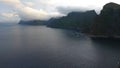 Aerial view of clouds moving over steep mountain peaks at midnight sun, Lofoten islands, Norway Royalty Free Stock Photo