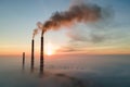 Aerial view of coal power plant high pipes with black smoke moving up polluting atmosphere at sunset Royalty Free Stock Photo
