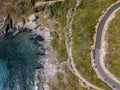 Aerial view of the coast of Corsica, winding roads and coves. Motorcyclists parked on the edge of a road. France