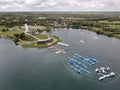 Aerial view of the coast of the Willen Lake in England with a tree field in the background