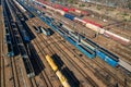 Aerial view of colorful freight trains on the railway station. Wagons with goods on railroad. Heavy industry. Industrial