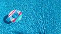 Aerial view of colorful inflatable ring donut toy in swimming pool water from above, family vacation concept Royalty Free Stock Photo
