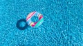 Aerial view of colorful inflatable ring donut toy in swimming pool water from above, family vacation concept Royalty Free Stock Photo