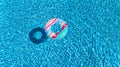 Aerial view of colorful inflatable ring donut toy in swimming pool water from above, family vacation concept Royalty Free Stock Photo