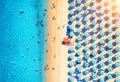 Aerial view of colorful umbrellas on sandy beach and blue sea