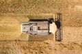 Aerial view of combine harvester harvesting large ripe wheat field. Agriculture from drone view Royalty Free Stock Photo