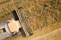 Aerial view of combine harvester harvesting large ripe wheat field. Agriculture from drone view Royalty Free Stock Photo