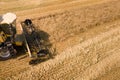 Aerial view of combine harvester harvesting large ripe wheat field. Agriculture from drone view Royalty Free Stock Photo