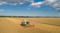 Aerial view combine harvester  harvesting on wheat field, cloudy sky Royalty Free Stock Photo