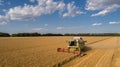 Aerial view combine, harvester, harvesting on wheat field, cloudy sky Royalty Free Stock Photo