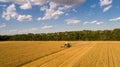 Aerial view combine (harvester) harvesting on wheat field, cloudy sky Royalty Free Stock Photo