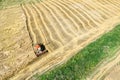 Aerial view of combine harvester in the partly harvested field