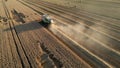 aerial view combine harvester cut thresh wheat grain in large field at early sunset in summer time Royalty Free Stock Photo