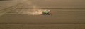 aerial view combine harvester cut thresh wheat grain in large field at early sunset in summer time Royalty Free Stock Photo