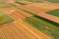 Aerial view of combine harvester and tractor with trailer harvesting ripe wheat field in summer