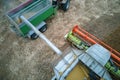 Aerial view of combine harvester unloading grain in cargo trailer working during harvesting season on large ripe wheat Royalty Free Stock Photo