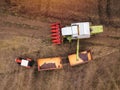 Aerial view of combine pouring harvested corn grains into trailer Royalty Free Stock Photo