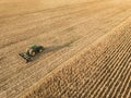 Aerial view on the combine working on the large corn field. Haymaking and harvesting in early autumn on the field. Tractor mows Royalty Free Stock Photo