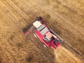 Aerial view on the combine working on the large wheat field. Haymaking and harvesting in early autumn on the field. Tractor mows